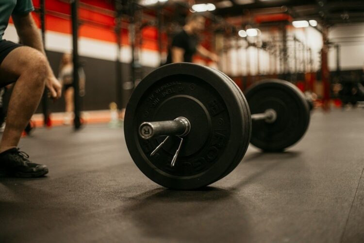 Skivstång med viktskivor på gymgolvet inför styrketräning